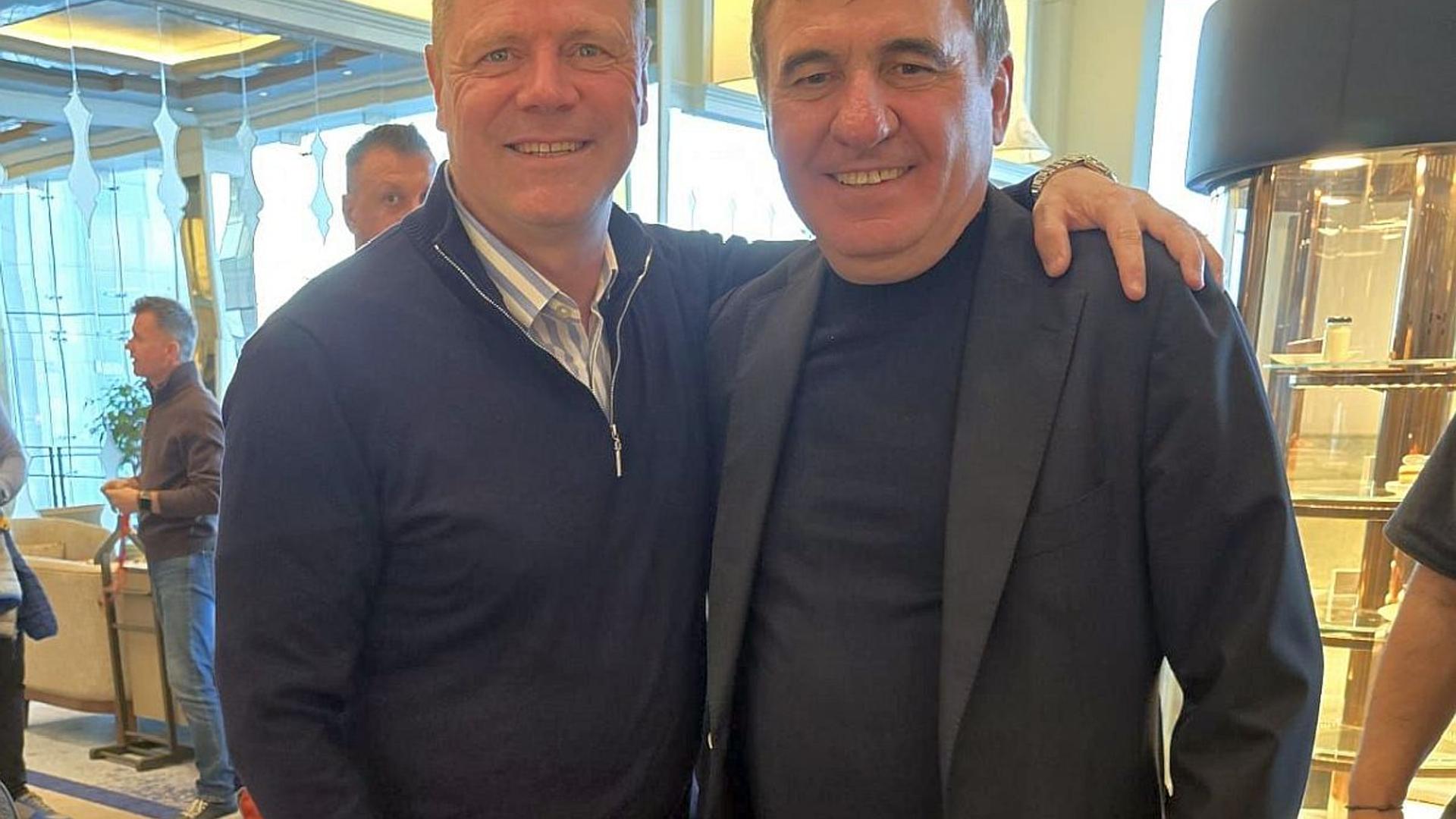 Gică Hagi discutând cu Andrei Borza pe marginea terenului în timpul unui meci al echipei naționale fotbal, cu jucători în acțiune în fundal | sursa foto: Gazeta Sporturilor
