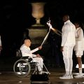Charles Coste, în scaun cu rotile, aprinzând torța lui Teddy Riner și Marie-Jose Perec, la ceremonia de deschidere a Jocurilor Olimpice de la Paris din 2024/Foto: Getty Images