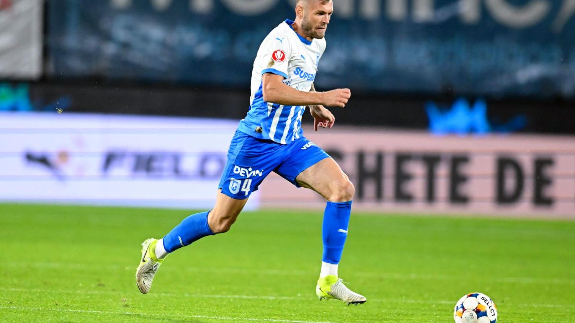 Alexandru Crețu în tricoul Universității Craiova, concentrat pe teren în timpul unui meci din Superliga România, pregătind duelul cu Dinamo. | sursa foto: Gazeta Sporturilor
