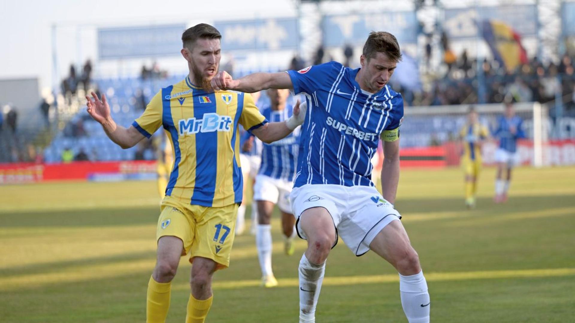 Stadionul Petrolul Ploiești gol, cu jucători antrenându-se în fundal, simbolizând insolvența și planul reorganizare judiciară pentru datorii club fotbal. | sursa foto: Gazeta Sporturilor