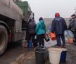 Oamenii stau la coadă pentru a lua apă în regiunea Mariupol