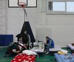 Un tânăr ucrainean care a fugit de război se odihnește într-un centru improvizat pentru refugiați într-o sală de sport din Isaccea, România.