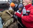 Locuitorii se înghesuie pentru a primi mâncare și alte articole oferite de membrii armatei ucrainene în Irpin, Ucraina