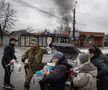 Locuitorii se înghesuie pentru a primi mâncare și alte articole oferite de membrii armatei ucrainene în Irpin, Ucraina