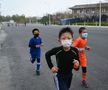 Copiii chinezi aleargă cu măști de protecție FOTO: Guliver/GettyImages