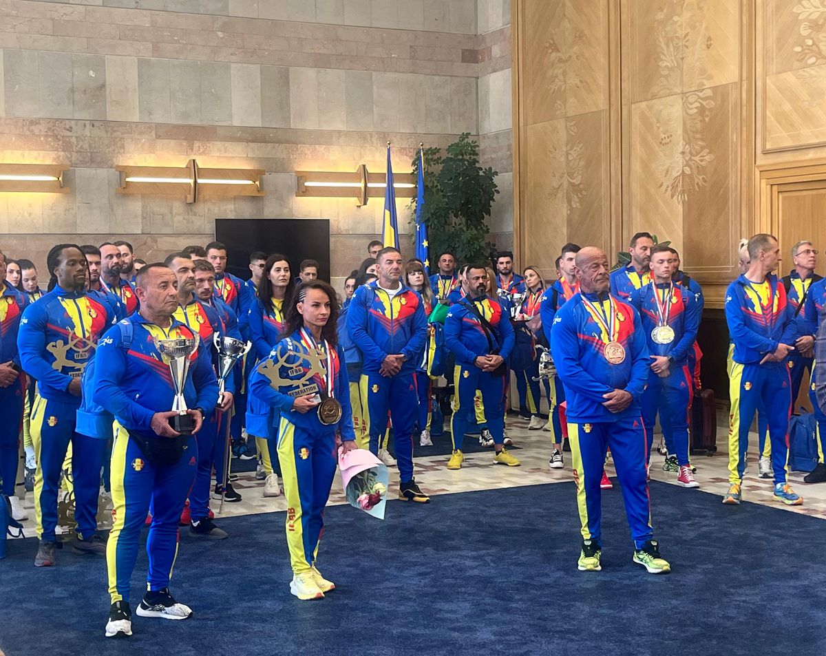 Românii campioni ai Europei la culturism și fitness au fost primiți în Salonul Oficial de la Otopeni » Veteranul lotului, Vasile Șerban, a explicat cum se motivează la 74 de ani