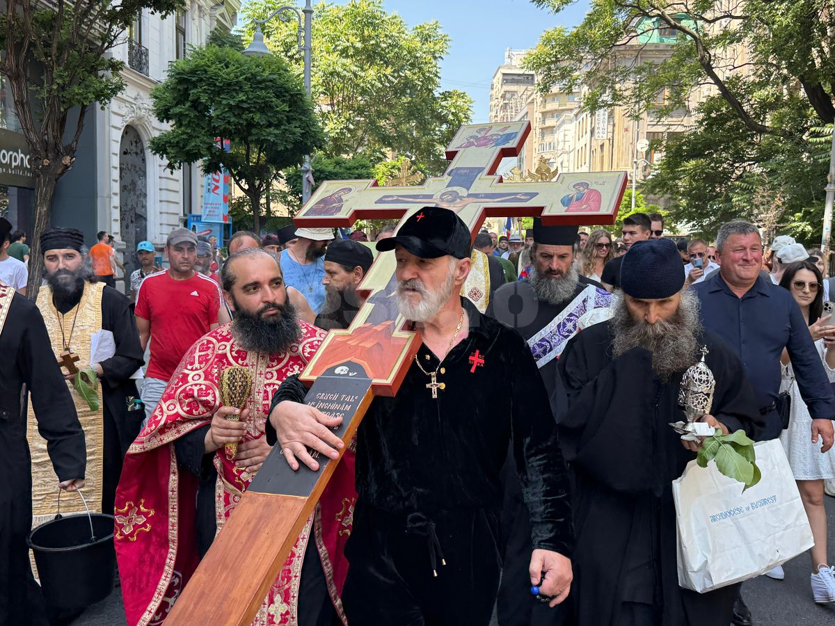 Gigi Becali a ieșit pe Calea Victoriei să „curețe” cu agheasmă după marșul LGBT: a purtat o cruce uriașă, apoi s-a oprit și a cântat