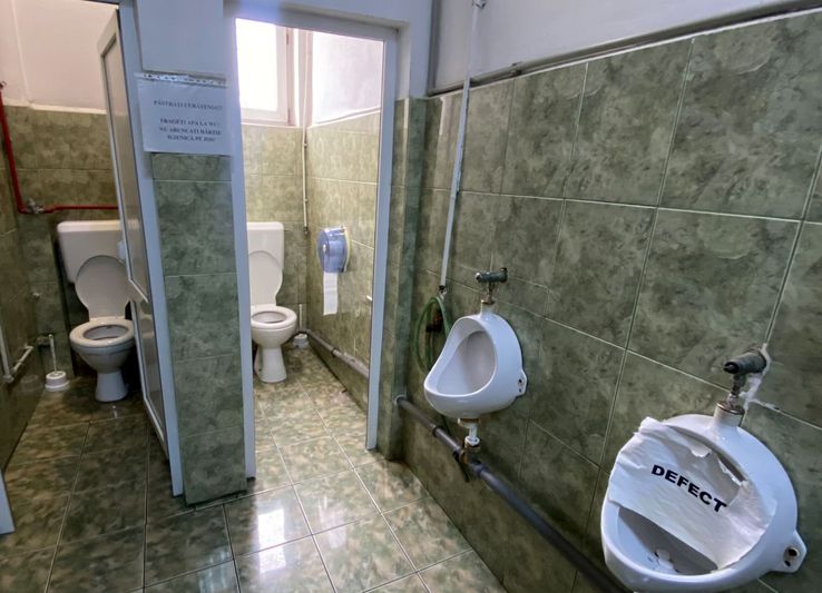 Două grupuri sanitare, instalații improvizate, un pișoar defect și instrucțiuni de folosire lipite pe pereți