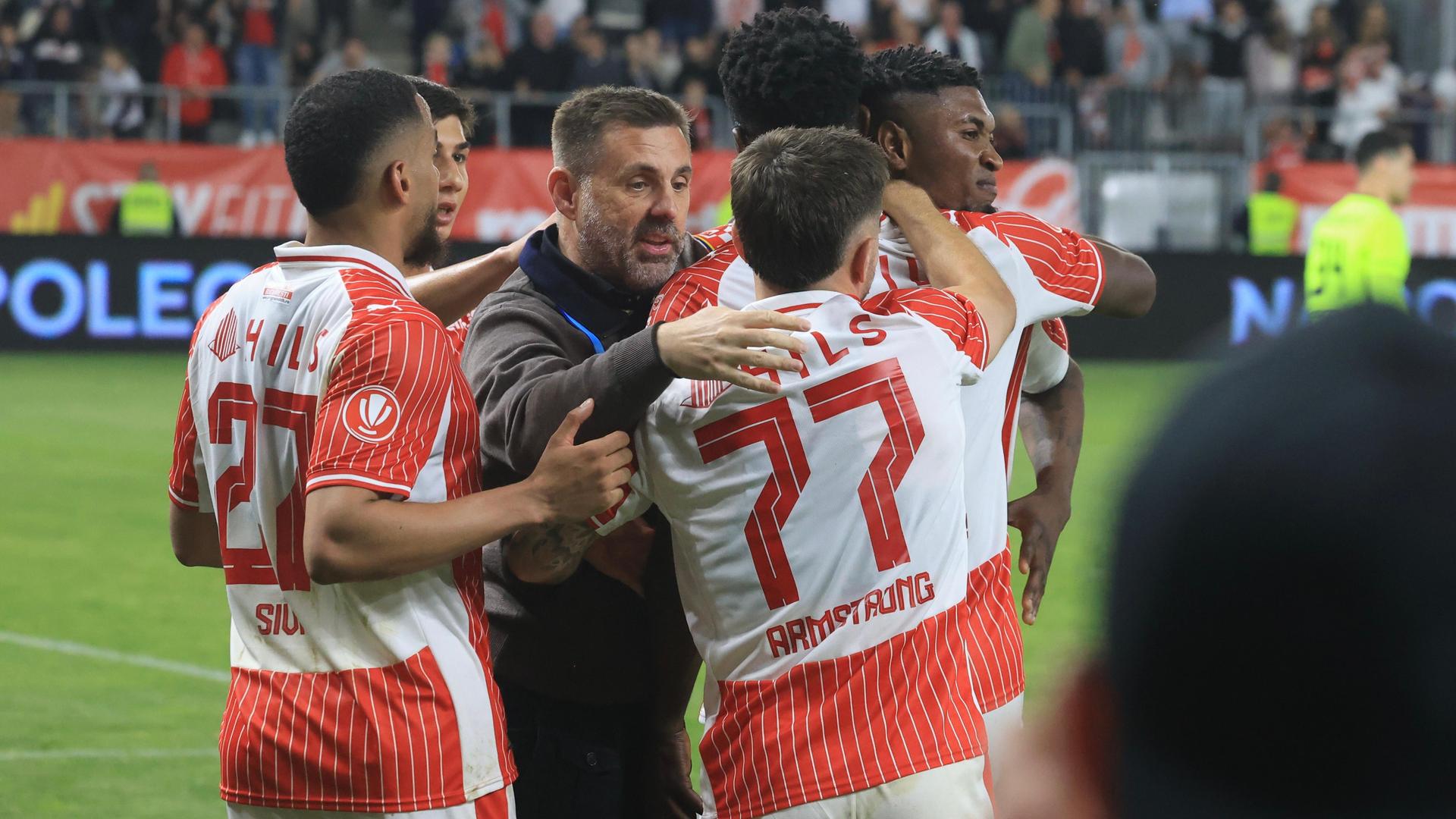 Danny Armstrong în tricoul alb-roșu al lui Dinamo București, semnând prelungirea contractului până în 2028 pe o masă oficială. | sursa foto: Gazeta Sporturilor Danny Armstrong în tricoul alb-roșu al lui Dinamo București, semnând prelungirea contractului până în 2028 pe o masă oficială. | sursa foto: Gazeta Sporturilor