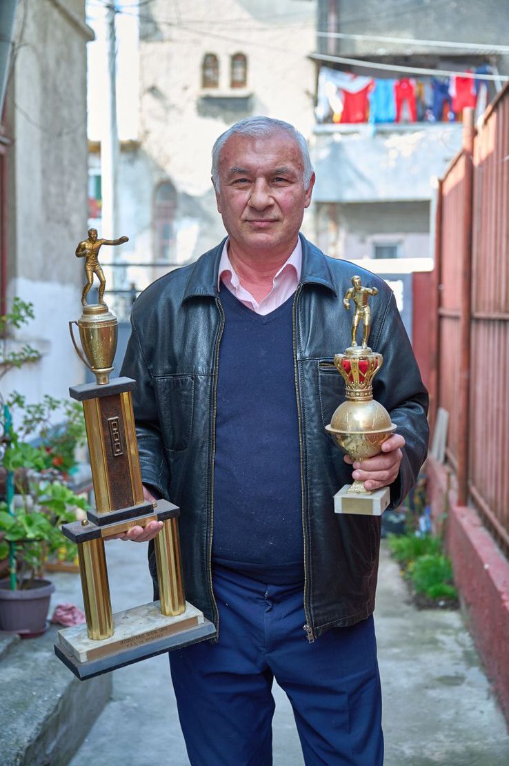 Ilie Dragomir pozând în curtea din Ferentari cu două dintre cele mai dragi cupe ale sale