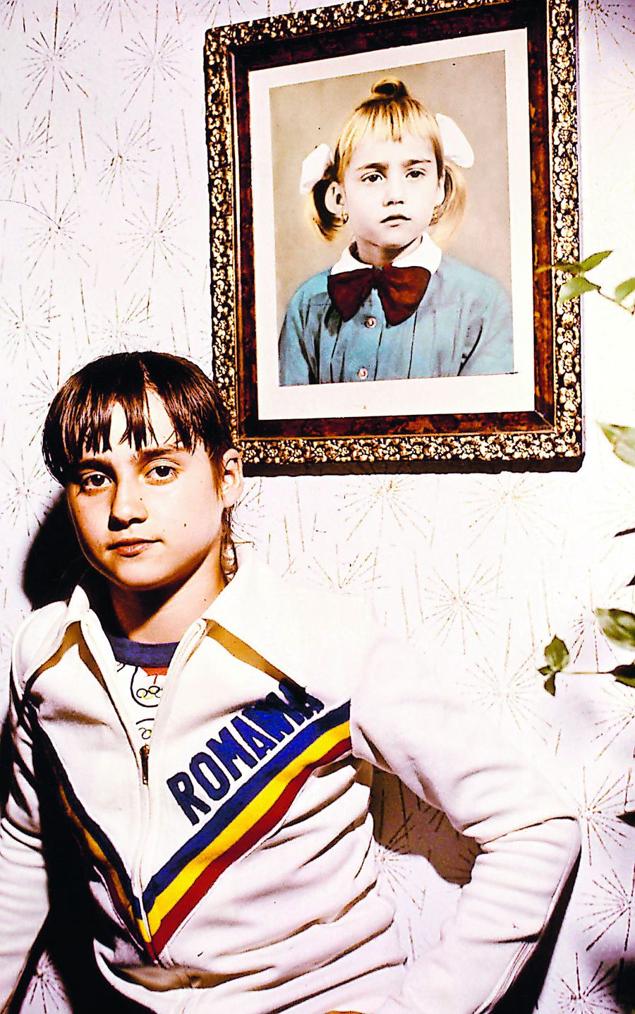Nadia Comăneci în 1976 având în spate un portret de când era la grădiniță // foto: Imago Images Perfecţiunea în 10 paşi » Drumul spectaculos al Nadiei Comăneci de la 6,20 și trei căzături la bârnă până la nota maximă de la Montreal