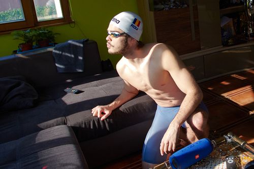 Robert Glință în echipamentul de înot, sprijinindu-se de canapeaua de acasă FOTO: Raed Krishan