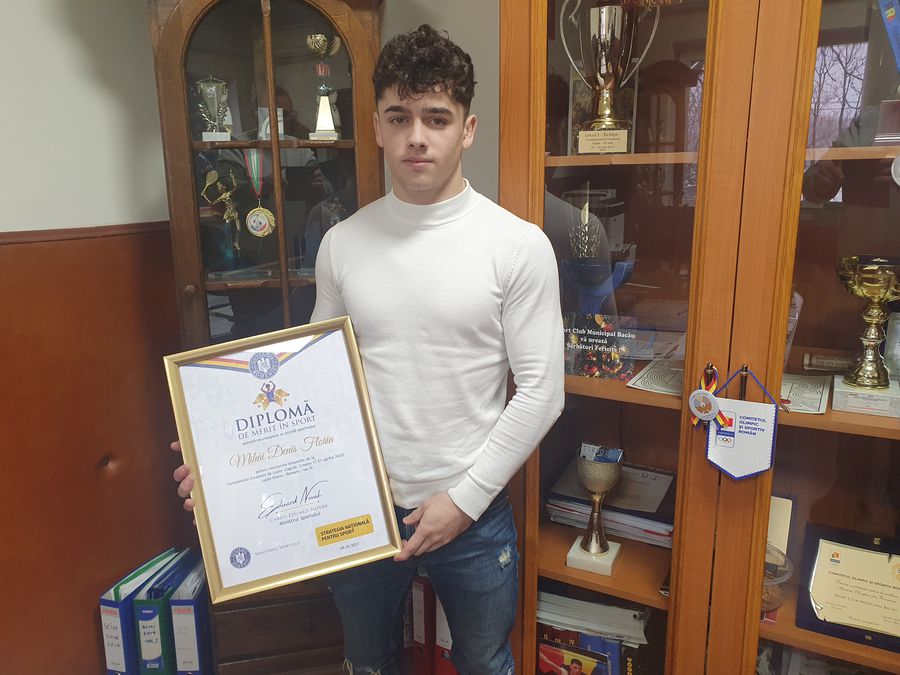 Denis Mihai la Bacău, cu o parte dintre trofeele și diplomele cucerite în carieră. Foto: Justin Gafiuc (GSP) Denis Mihai, puștiul-fenomen din lupte: „Medalie la Olimpiada de la Los Angeles! Doar așa intru în istorie!” + Amintiri din familie: „Mai veneam acasă cu un ochi vânăt”