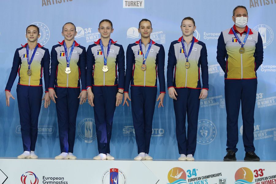 Echipa de junioare a României alături de antrenorul Lucian Sandu pe podium la Mersin FOTO Imago-Images România a pierdut aurul la Campionatele Europene de la Mersin, o ediție de la care au lipsit marile puteri ale gimnasticii