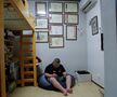 Kyuta se joacă un joc în dormitorul său. Pe perete sunt medaliile și premiile sale. // Foto: Reuters