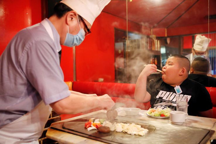Kyuta se bucură de o friptură cu care tatăl său îl recompensează după un antrenament. În medie, el trebuie să consume între 2.700 și 4.000 de calorii pe zi, inclusiv un litru de lapte și multe proteine. Friptura este mâncarea lui preferată.  // Foto: Reuters