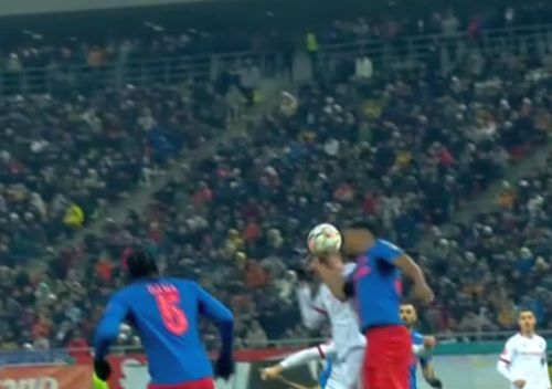 Ngezana sare cu brațele sus. Mingea îl lovește în cel drept