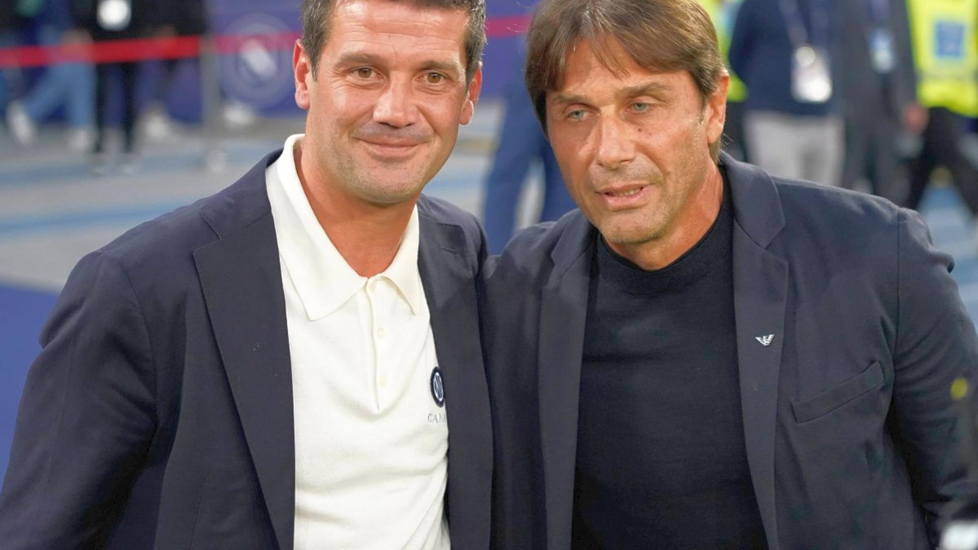 Cristi Chivu și Antonio Conte discutând tactic în timpul derby-ului Inter Napoli din Serie A, cu jucători pe teren în fundal. | sursa foto: Gazeta Sporturilor Cristi Chivu și Antonio Conte discutând tactic în timpul derby-ului Inter Napoli din Serie A, cu jucători pe teren în fundal. | sursa foto: Gazeta Sporturilor