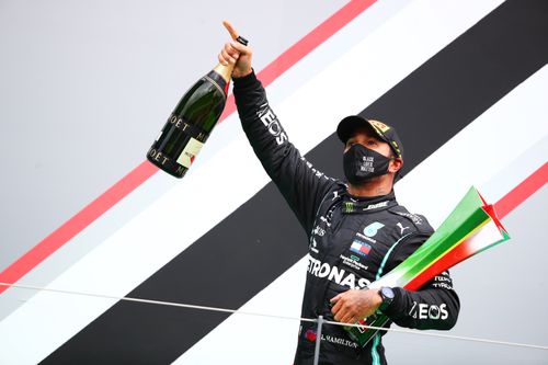 Lewis Hamilton sărbătorind a 92-a victorie cu trofeul din Portugalia și sticla de șampanie FOTO Guliver/GettyImages