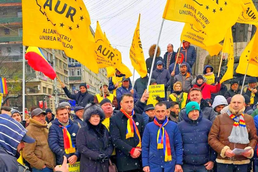 Ciprian Paraschiv, cu palton negru și eșarfă tricoloră la gât, la acțiunile AUR Iași / Sursă foto: Facebook